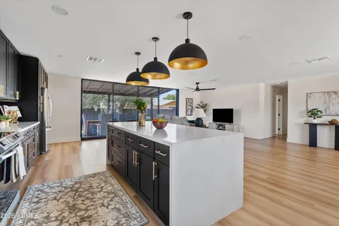 a kitchen with stainless steel appliances granite countertop a sink a stove and a wooden floors