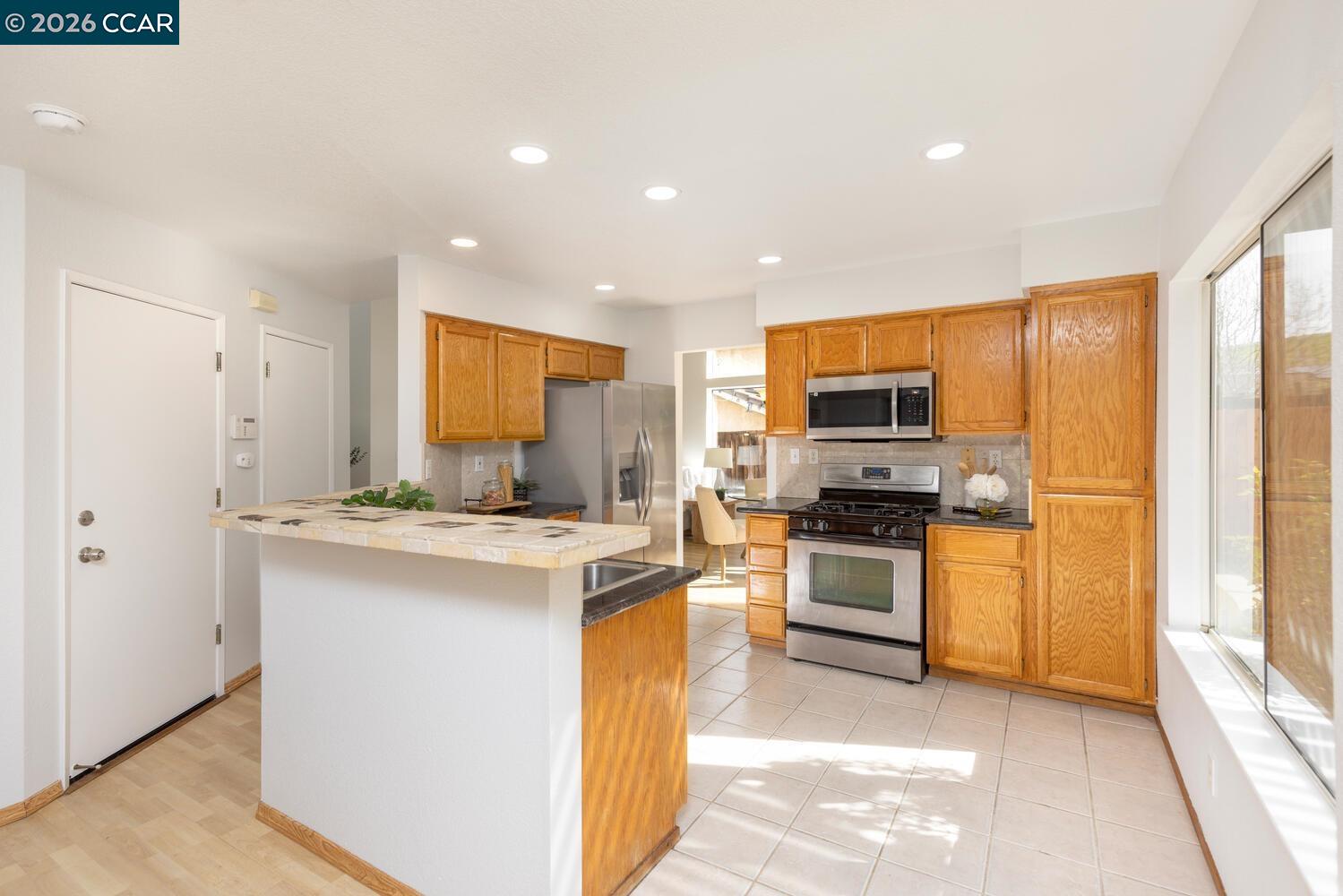 558 Fletcher Street Bay Point, CA 94565 - Photo 17 of 37 a kitchen with stainless steel appliances granite countertop a stove top oven a refrigerator a sink and dishwasher with white cabinets