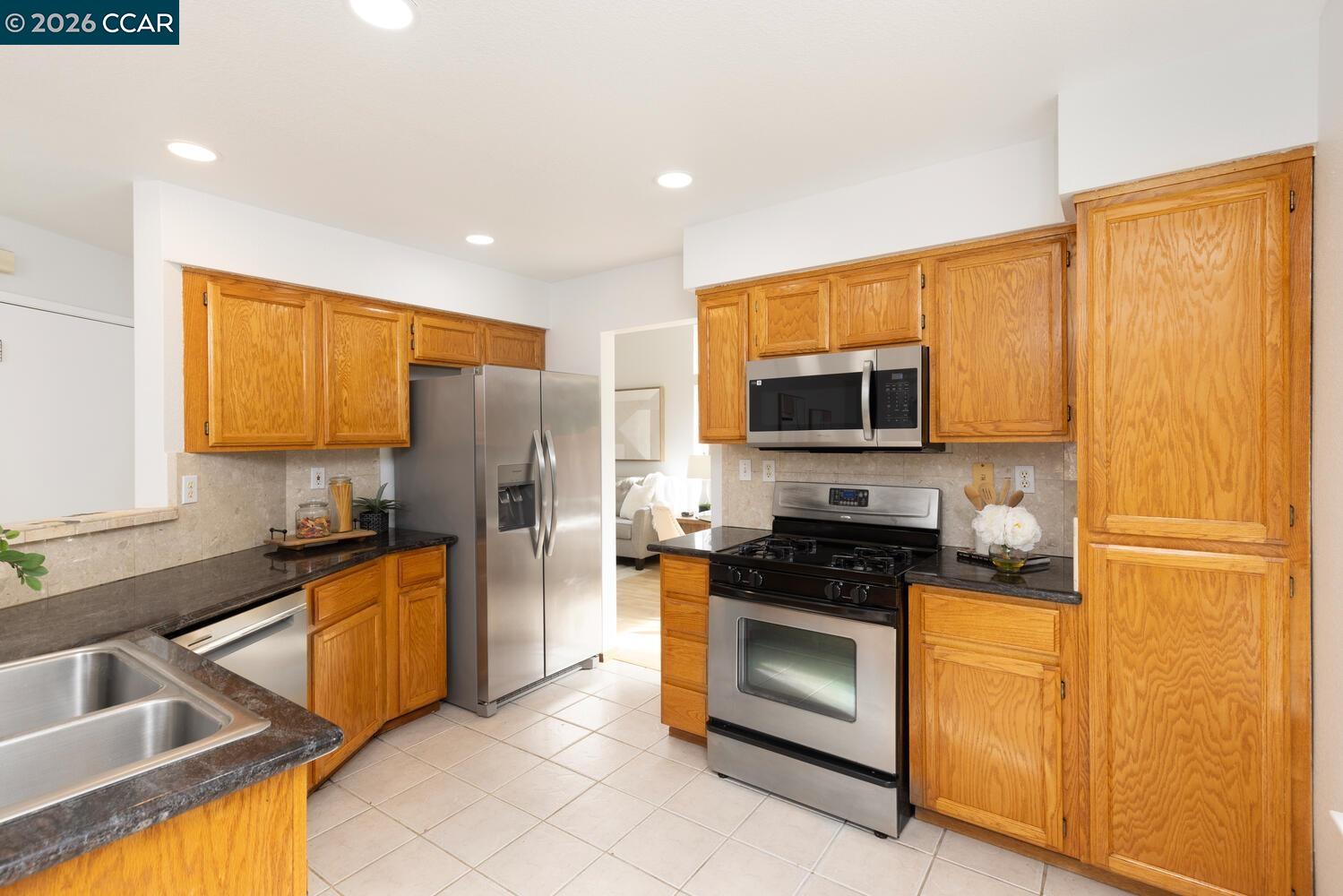 558 Fletcher Street Bay Point, CA 94565 - Photo 18 of 37 a kitchen with granite countertop stainless steel appliances a stove refrigerator and microwave
