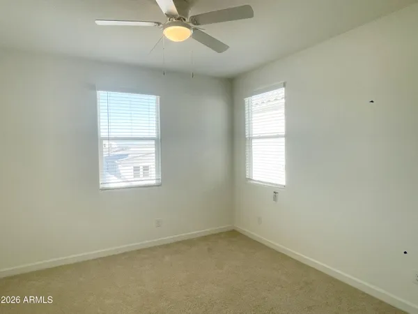 an empty room with a window and a fan
