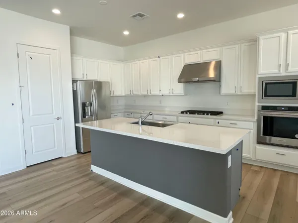a kitchen with stainless steel appliances a sink a stove a refrigerator and cabinets