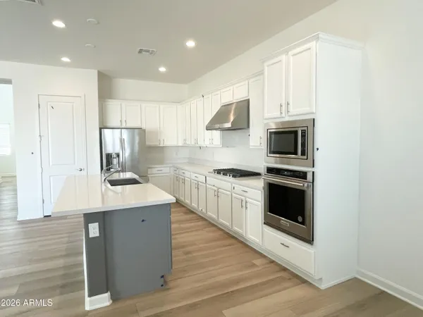 a kitchen with stainless steel appliances kitchen island granite countertop a stove a sink and a microwave