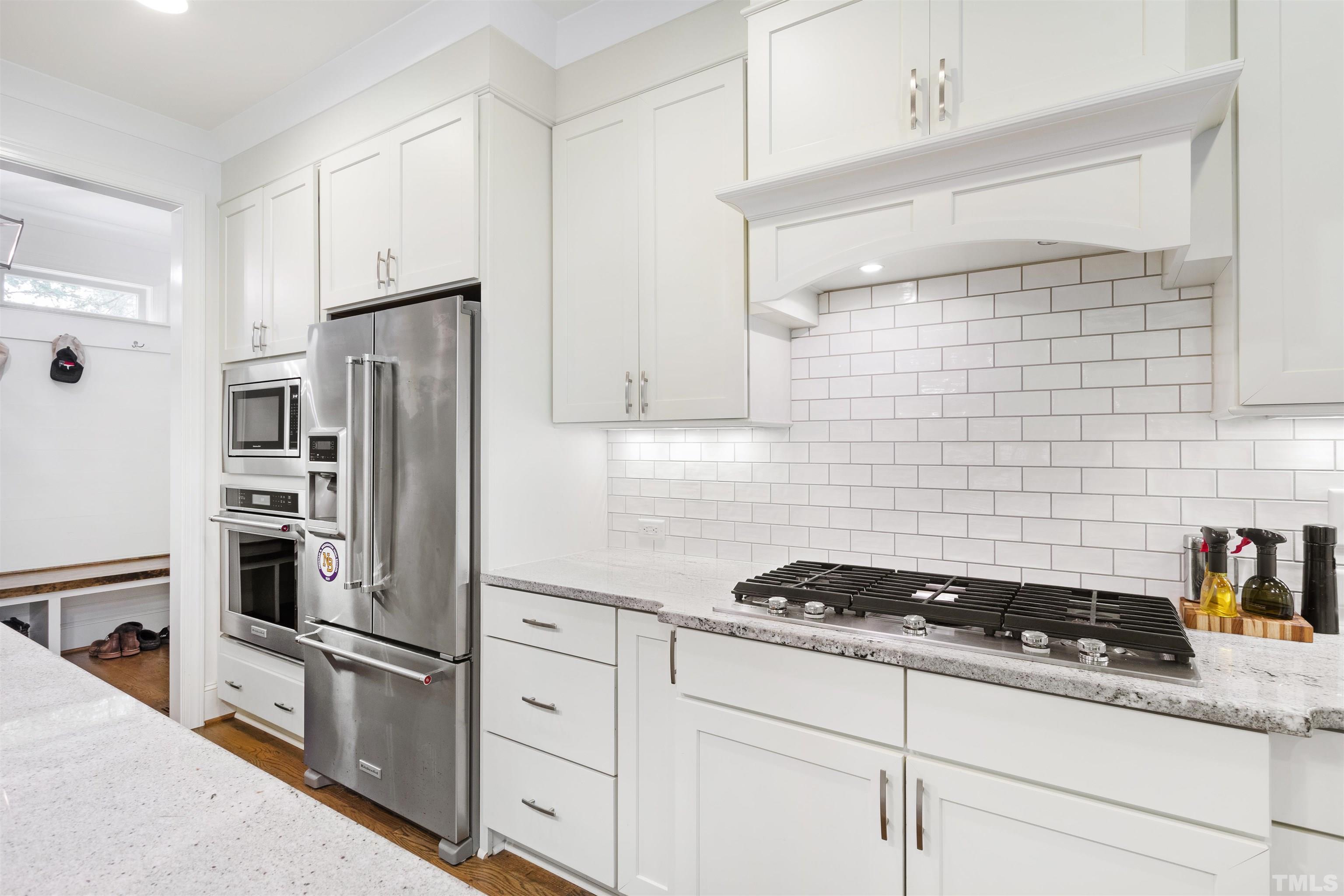 3205 Plantation Road Raleigh, NC 27609 - Photo 14 of 39 a kitchen with refrigerator a stove a sink and cabinets