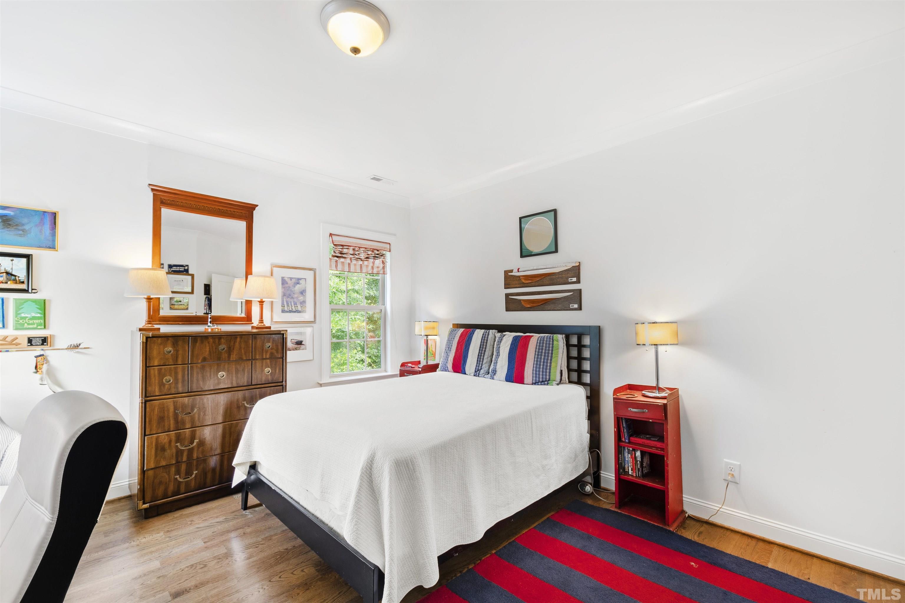 3205 Plantation Road Raleigh, NC 27609 - Photo 22 of 39 a bedroom with a bed and a book shelf