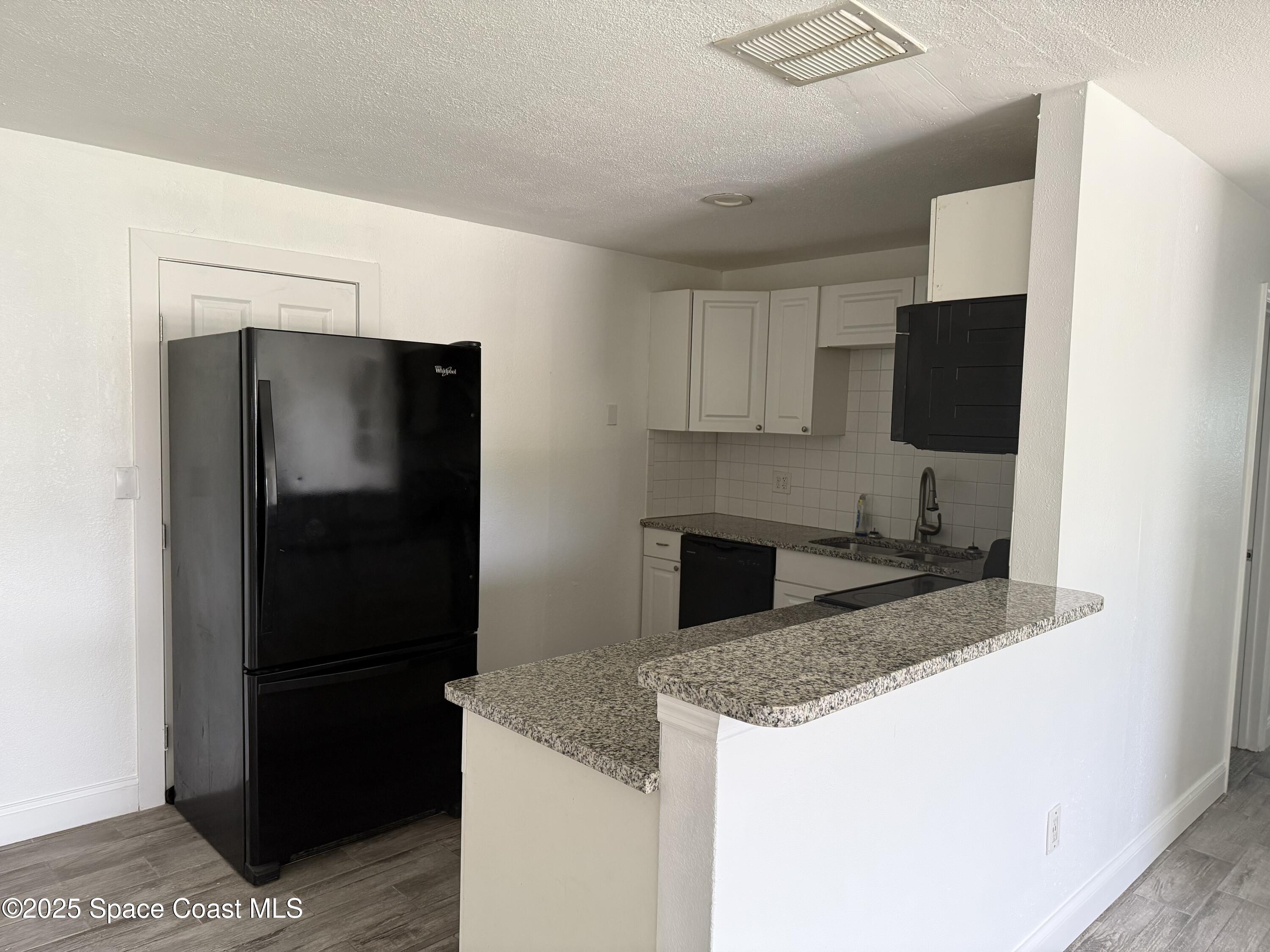 2806 Tropic Road, Unit 1 Melbourne, FL 32935 - Photo 2 of 7 a kitchen with a sink and a refrigerator