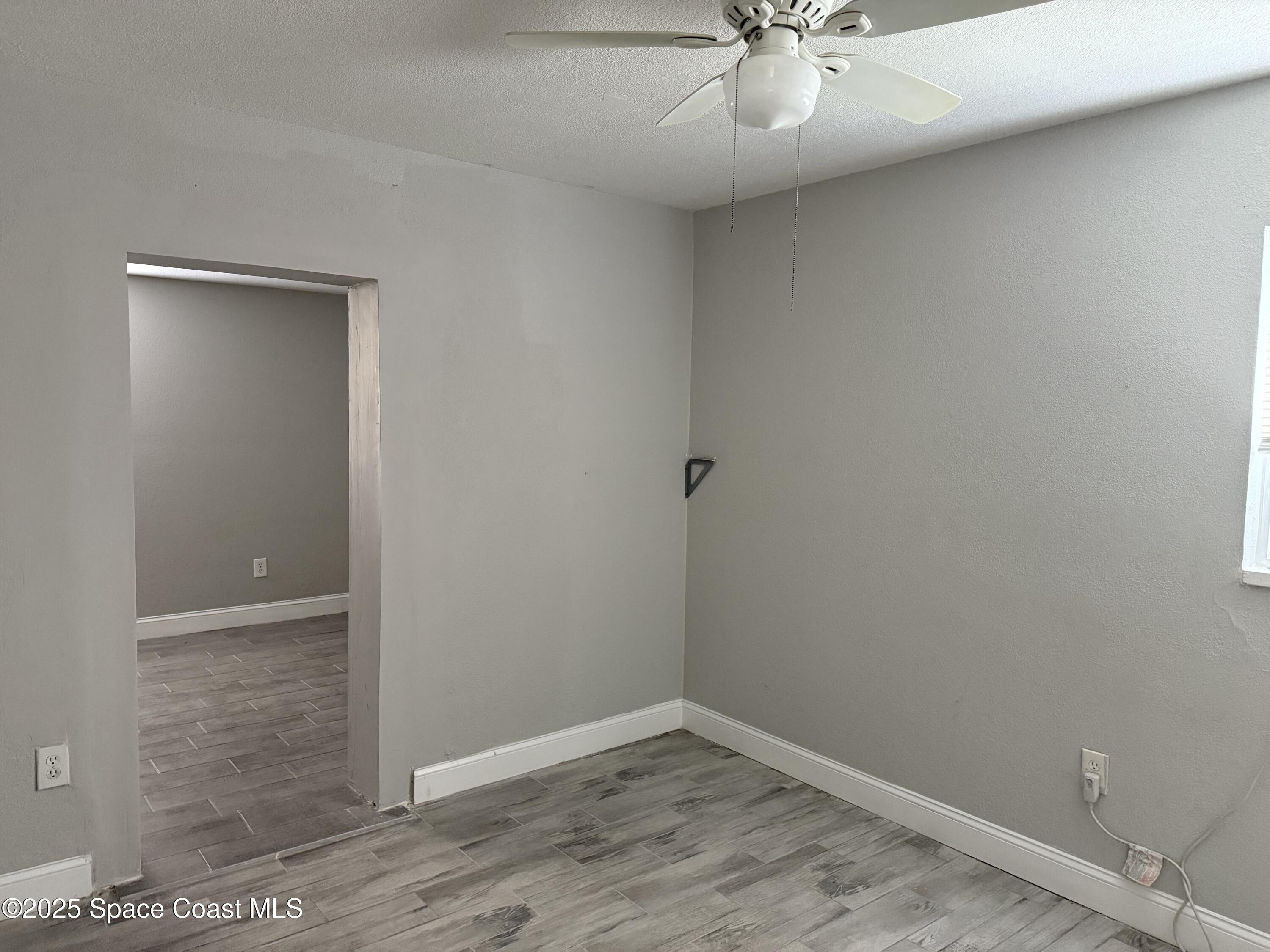 2806 Tropic Road, Unit 1 Melbourne, FL 32935 - Photo 4 of 7 an empty room with a ceiling fan and carpet