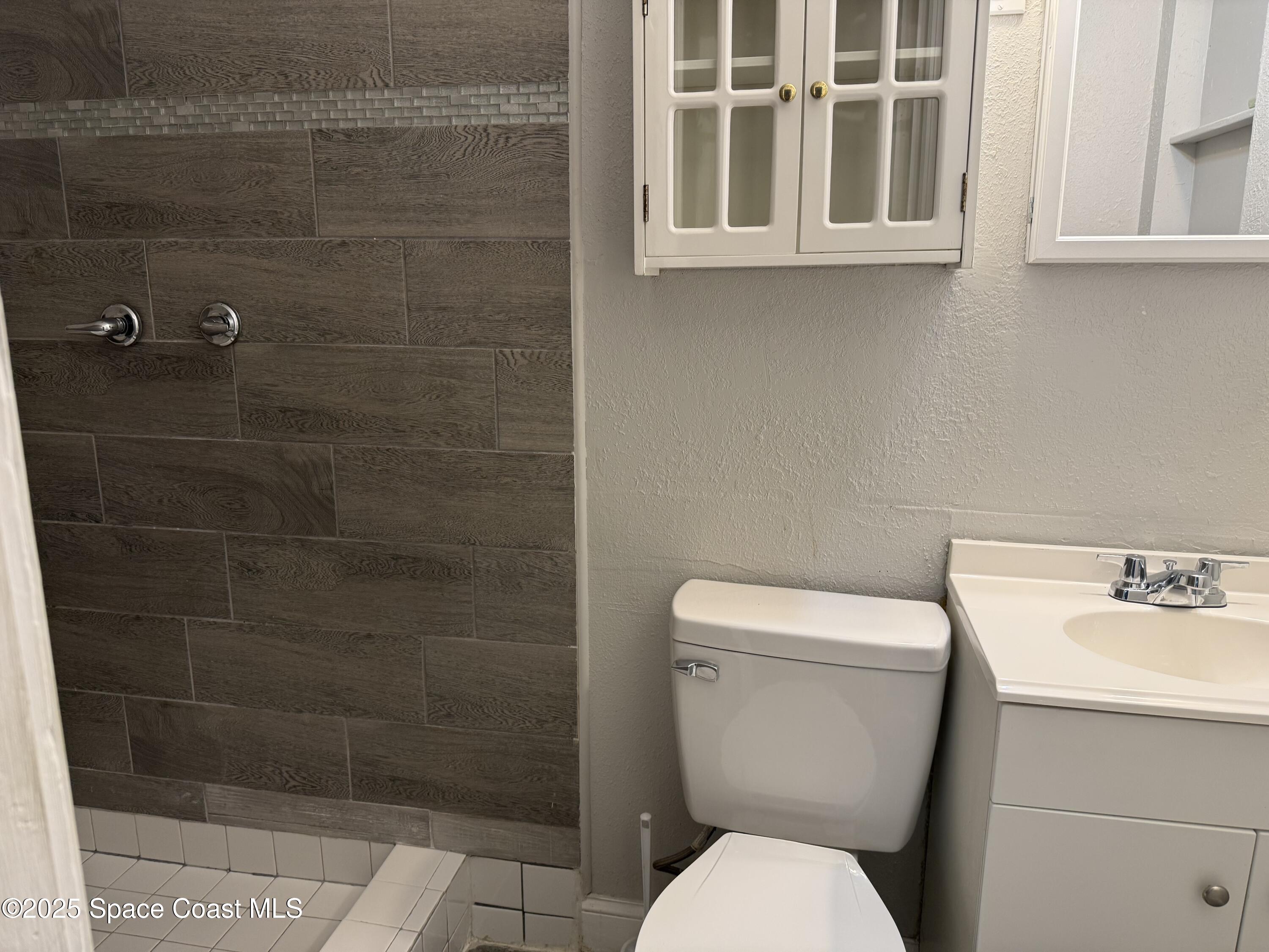 2806 Tropic Road, Unit 1 Melbourne, FL 32935 - Photo 5 of 7 a white toilet sitting next to a bathroom sink