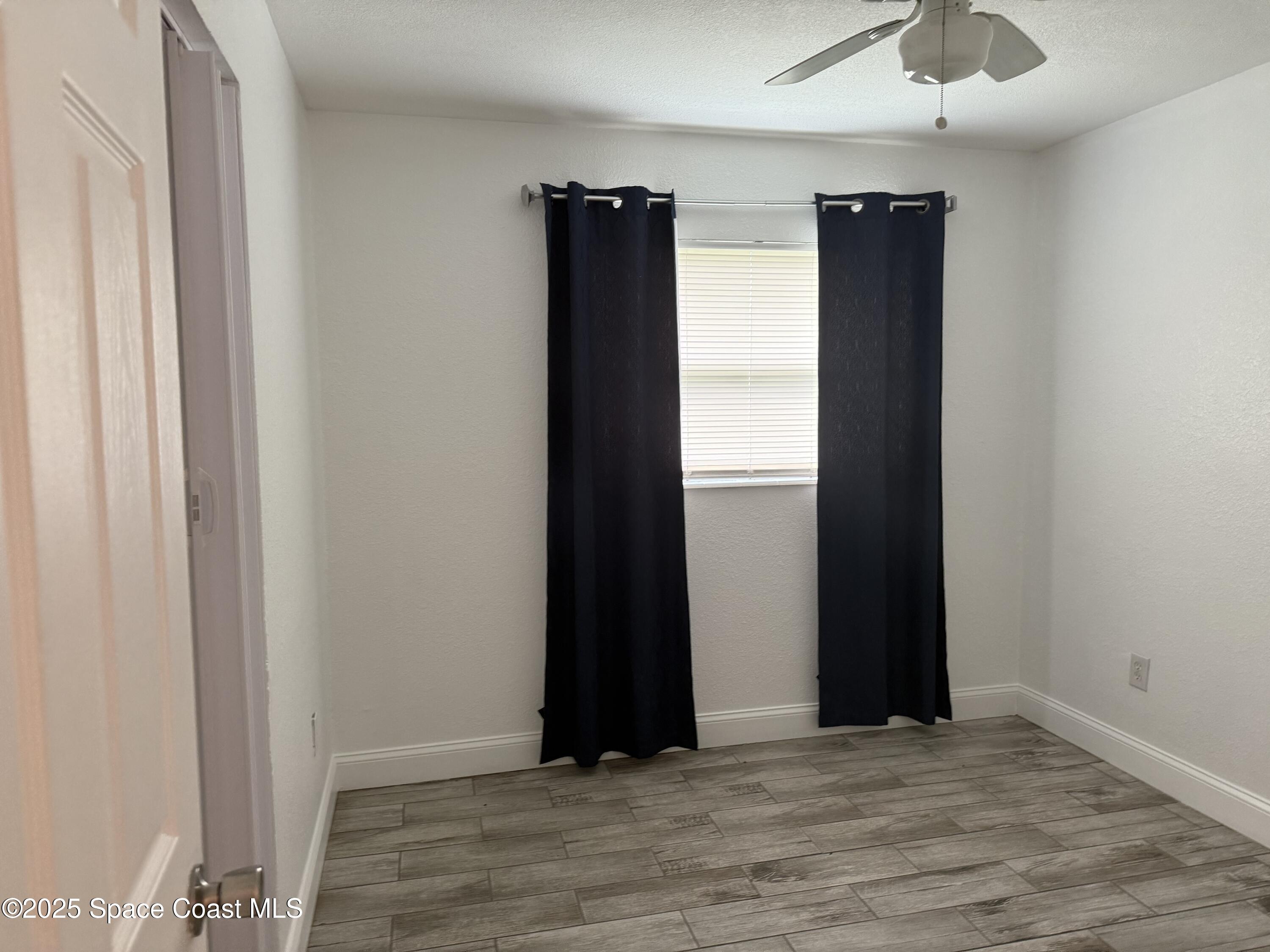 2806 Tropic Road, Unit 1 Melbourne, FL 32935 - Photo 6 of 7 an empty room with wooden floor closet and windows