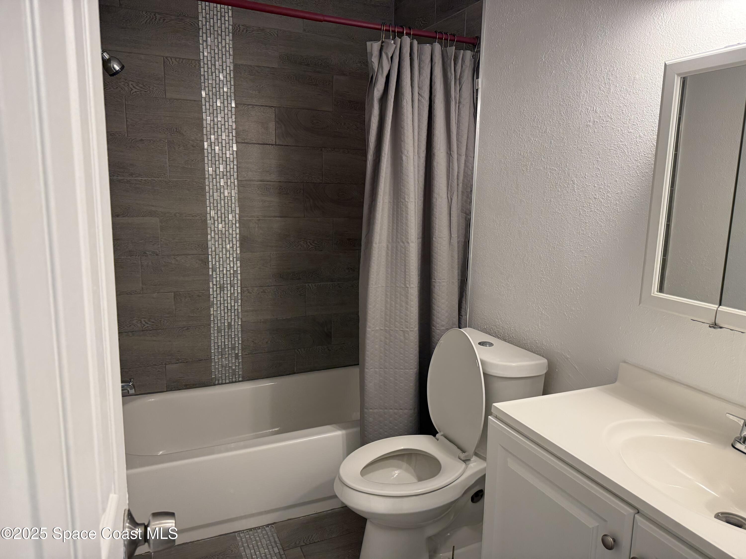 2806 Tropic Road, Unit 1 Melbourne, FL 32935 - Photo 7 of 7 a bathroom with a sink a toilet and shower