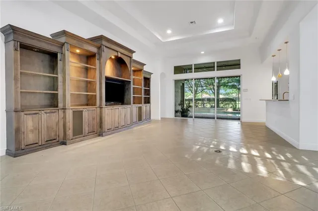 a view of an empty room with a window and cabinet