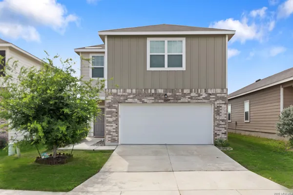 a front view of a house with a garden