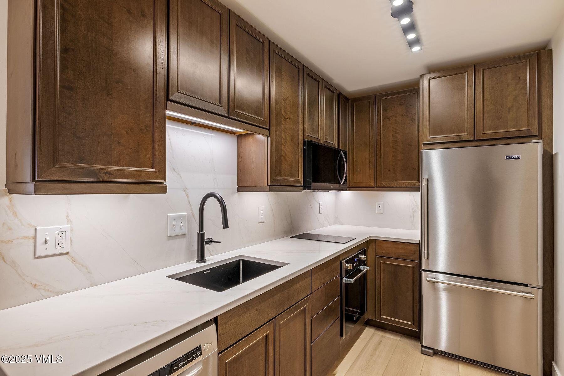 4133 Spruce Way, Unit 6 Vail, CO 81657 - Photo 6 of 11 a kitchen with stainless steel appliances granite countertop a refrigerator and a sink