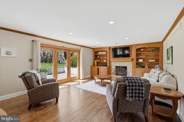 a living room with furniture a fireplace and a large window