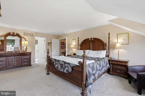 a bedroom with a bed and a dresser with mirror
