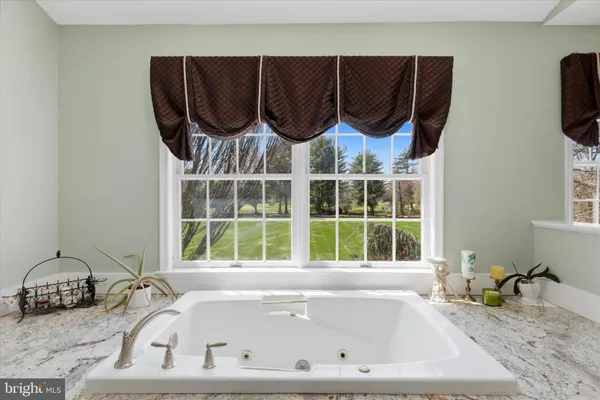 a bathroom with a granite countertop sink and a bathtub