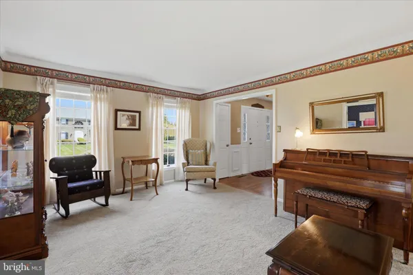 a living room with furniture a piano and a flat screen tv