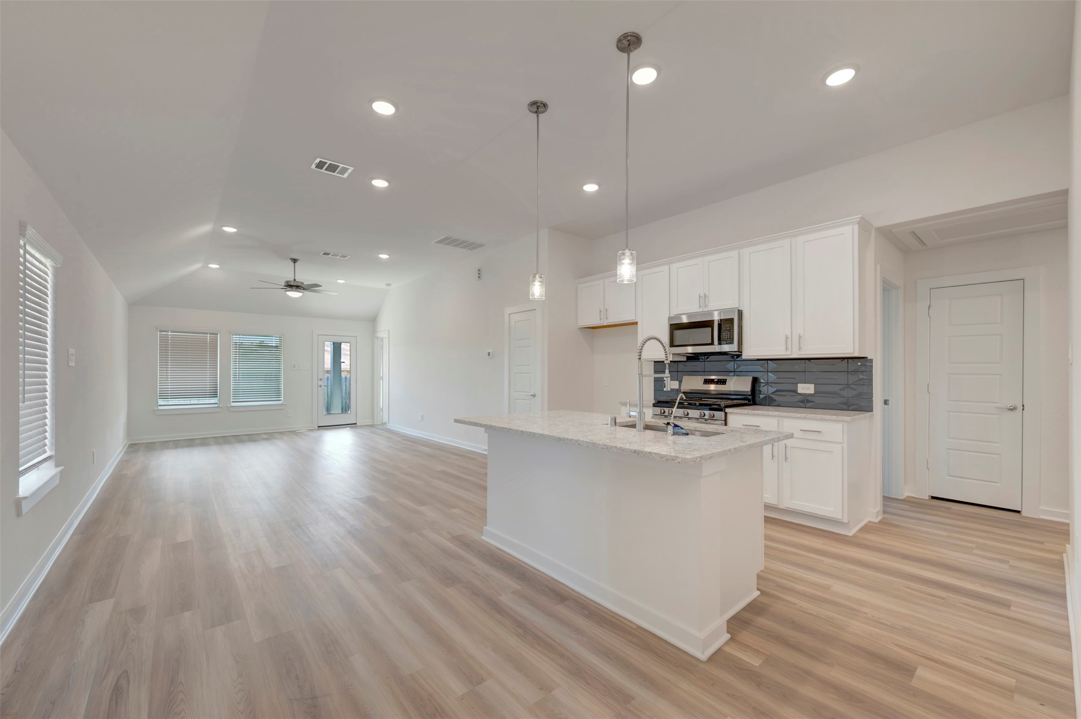 249 Hazy Pnes Lane Willis, TX 77378 - Photo 15 of 38 a kitchen with stainless steel appliances granite countertop a sink a stove a refrigerator and white cabinets with wooden floor