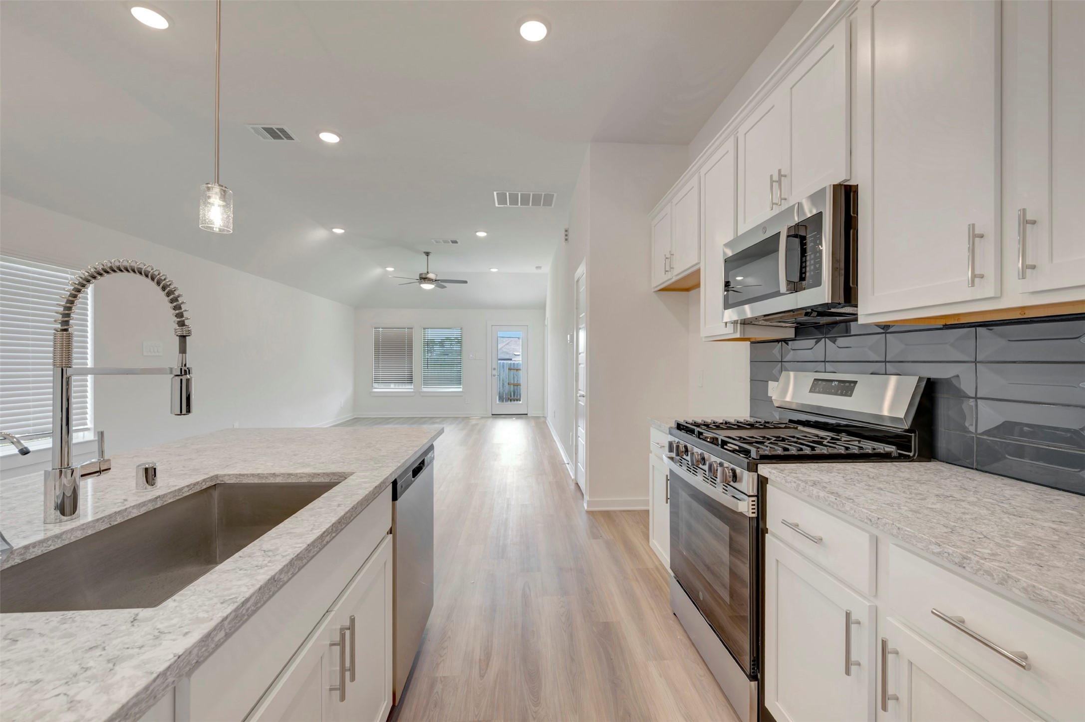 249 Hazy Pnes Lane Willis, TX 77378 - Photo 16 of 38 a kitchen with stainless steel appliances granite countertop a sink a stove top oven and wooden floors