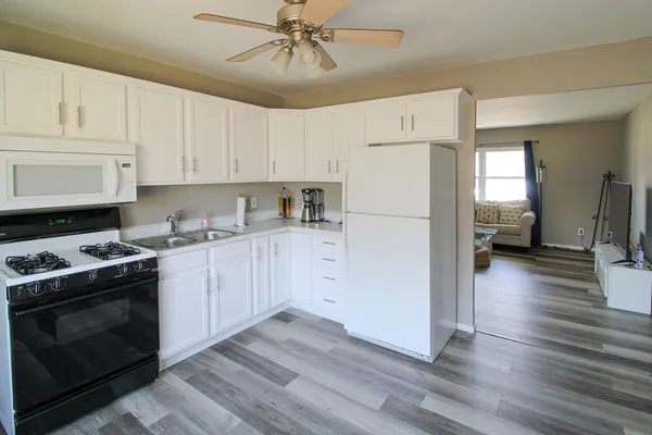 a kitchen with a refrigerator stove and white cabinets