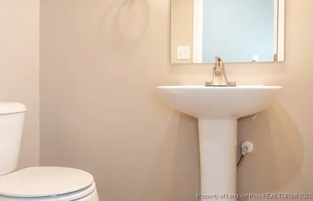 a bathroom with a sink a toilet and mirror