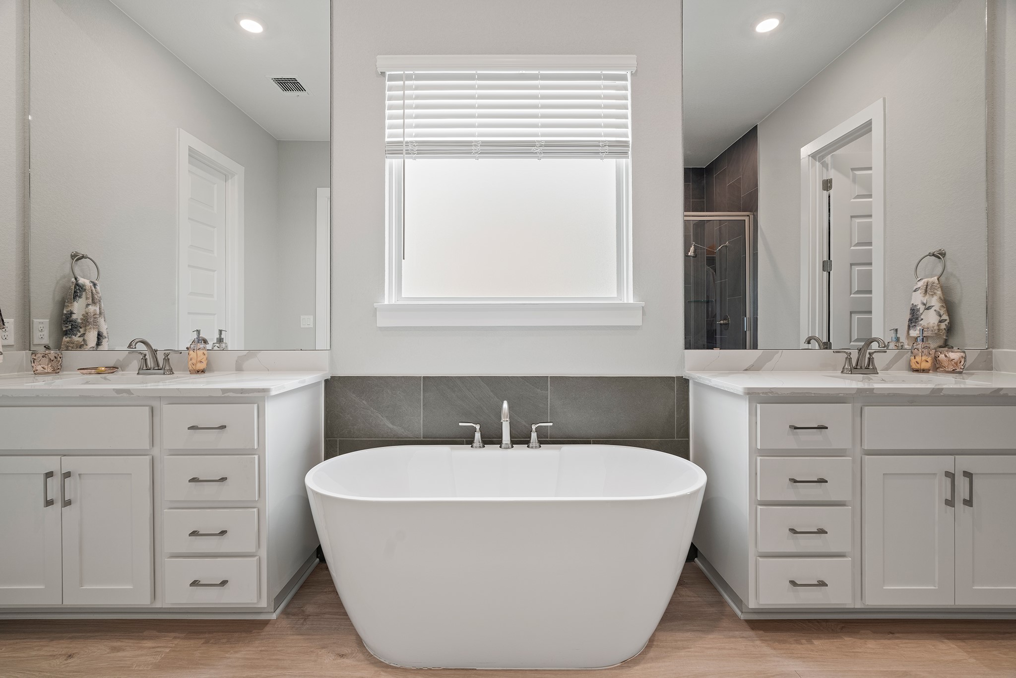 2112 Tobiano Trace Georgetown, TX 78633 - Photo 21 of 40 Full bath with tile walls, light wood-style flooring, a stall shower, recessed lighting, and two vanities