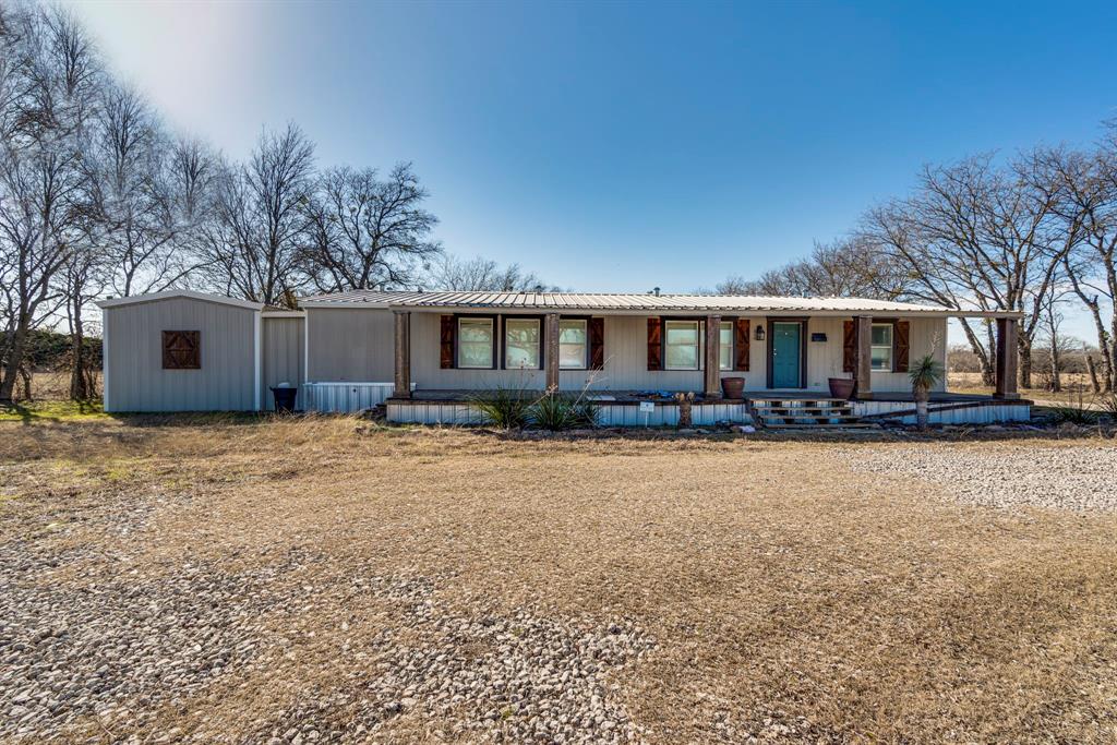 3444 East E Highway Midlothian, TX 76065 - Photo 22 of 26 a front view of house with yard and trees in the background
