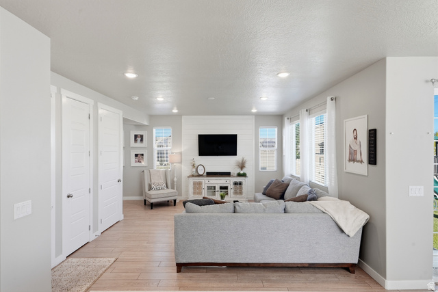 3244 West 1670th Street North Provo, UT 84601 - Photo 20 of 56 Spacious living area featuring wood-finish flooring, recessed lighting, multiple windows with blinds, and a shiplap accent wall