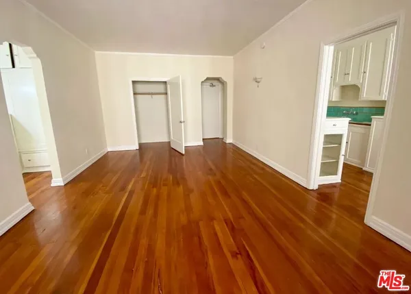 a view of empty room with wooden floor