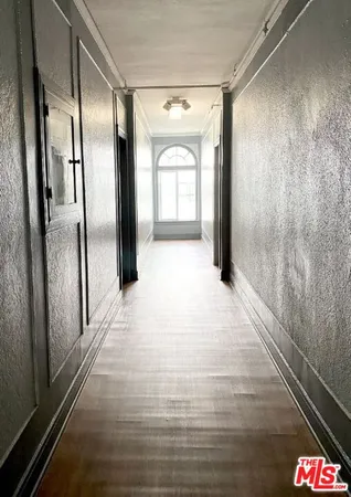 a view of a hallway with wooden floor and a large window