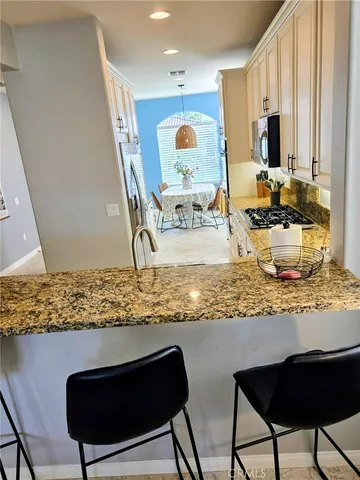 a kitchen with stainless steel appliances granite countertop a refrigerator and a stove top oven