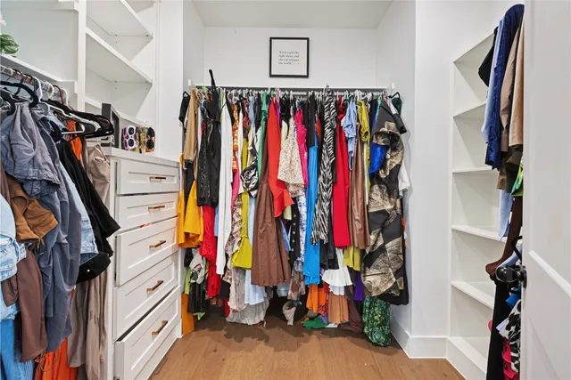 a view of walk in closet with clothes