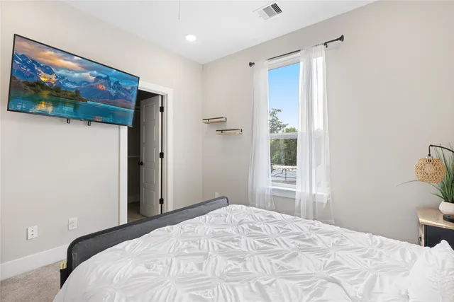 a bedroom with a bed and a painting on the wall