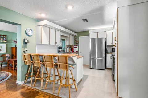 a kitchen with stainless steel appliances granite countertop a refrigerator and a stove top oven