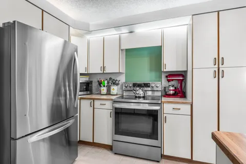 a kitchen with stainless steel appliances a refrigerator sink and cabinets