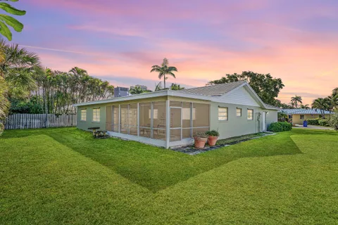 a view of a yard in front of a house with a large tree