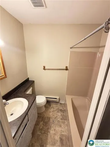 a bathroom with a granite countertop sink toilet and a mirror