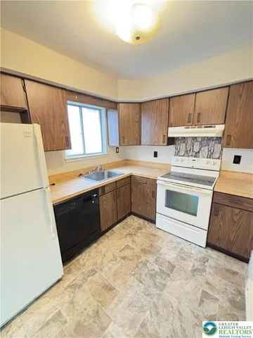 a kitchen with a stove sink and a refrigerator