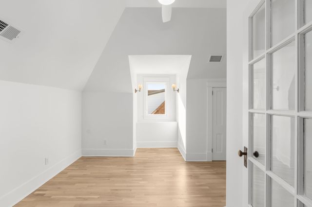 a bedroom with a bed a window and a chandelier