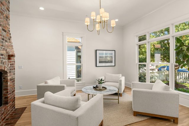 a living room with furniture a fireplace and chandelier
