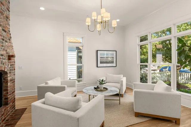 a living room with furniture a fireplace and chandelier