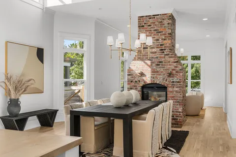 a kitchen with stainless steel appliances granite countertop a table chairs sink and cabinets