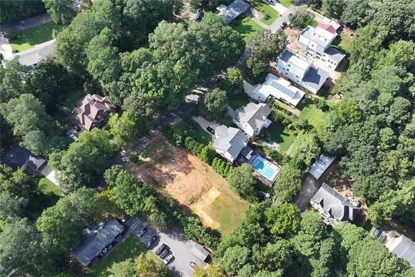 an aerial view of residential house with outdoor space and trees all around