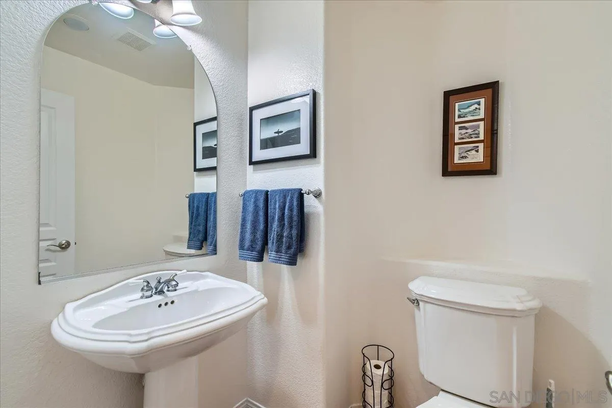 1382 Sparrow Road Carlsbad, CA 92011 - Photo 27 of 34 a bathroom with a sink a mirror and a toilet