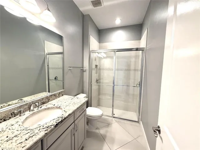 a bathroom with a granite countertop sink toilet and shower