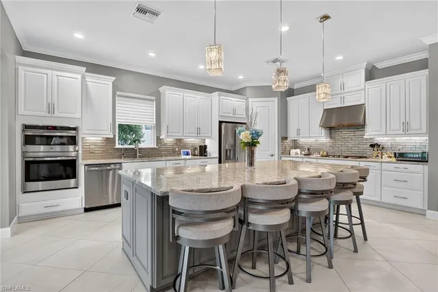a kitchen with kitchen island granite countertop wooden cabinets and stainless steel appliances