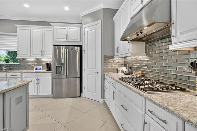a kitchen with stainless steel appliances granite countertop a stove a refrigerator and a sink