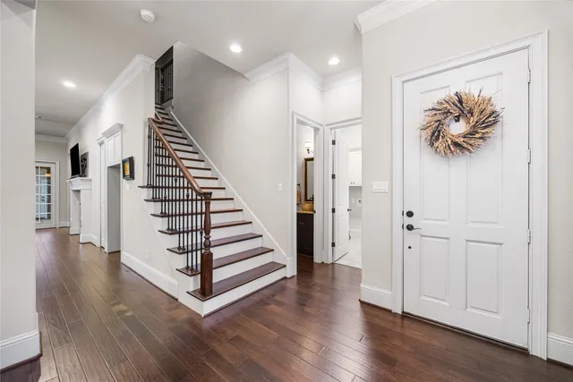 a view of a hallway with wooden floor and stairs
