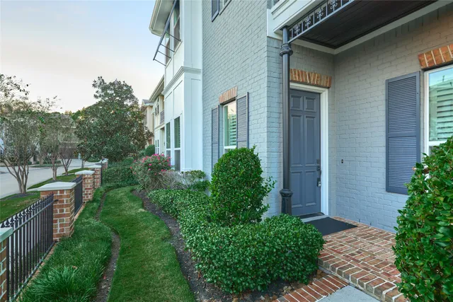 a view of a brick house with a yard and plants