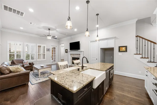 a living room with granite countertop kitchen island furniture and a flat screen tv