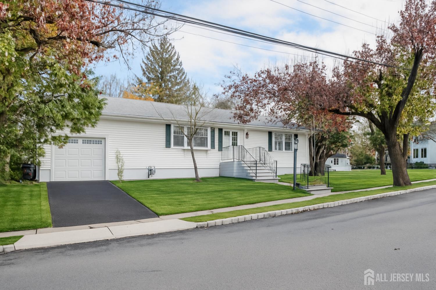 a view of a house with a yard and large tree